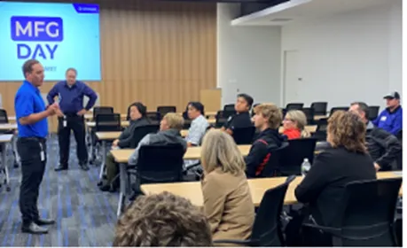 photo of a person presenting to a large room of people