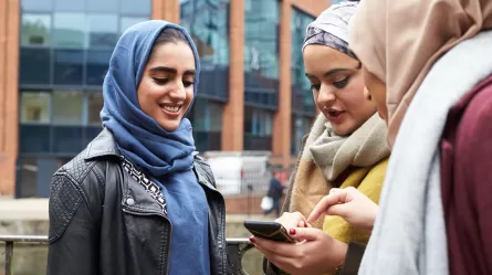 Three women looking at phone