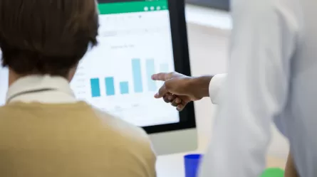 Labor market Analysts working on a graph together on their computer. 