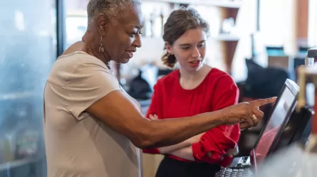 woman restaurant owner showing younger employee how to do something
