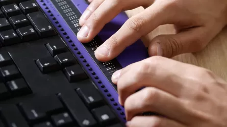 man using braille keyboard adapter for computer
