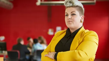 woman on a job interview at a creative or entertainment company, people meeting in background
