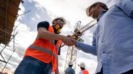 Construction worker shaking hands with foreman on job site