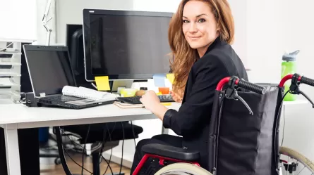 Woman in wheelchair at desk in office