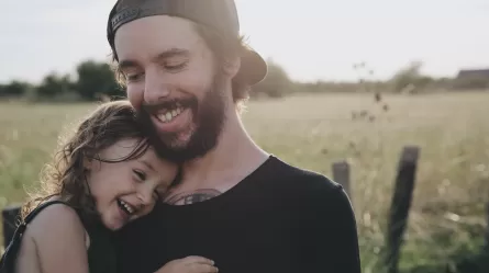 young man holding his child Photo by Caroline Hernandez from Unsplash