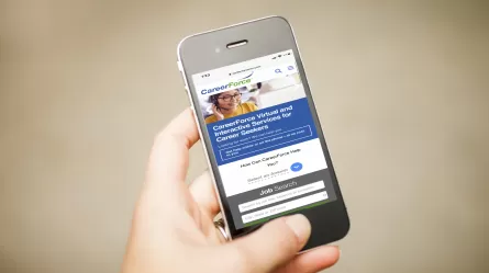 hand on cell phone CareerForceMN.com on screen