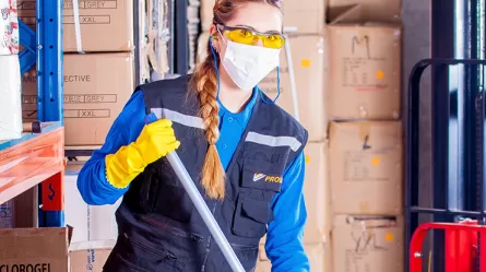 Cleaning worker holding mop in protective gear