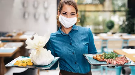 Food Service Worker holding two plates in a restaurant