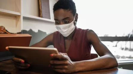 woman in mask using laptop