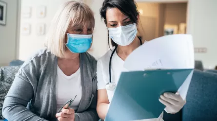 personal care aid and patient both wearing masks