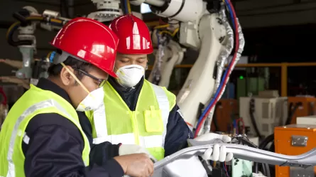 Assembly workers inspecting a part