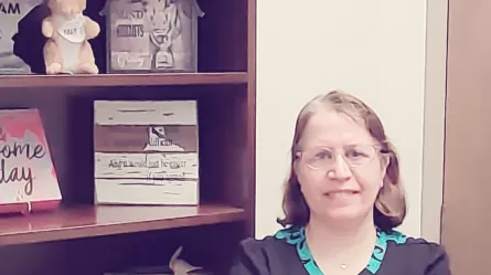 Photo of Rangineh standing by bookshelf.