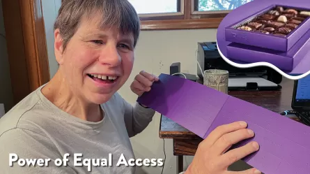 Lisa, a smiling woman, holding braille key from a box of Purdy’s chocolates