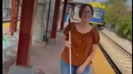 Sheila Koenig holding white cane at light rail station