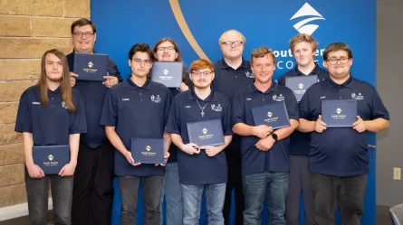 nine young people holding certificates of graduation