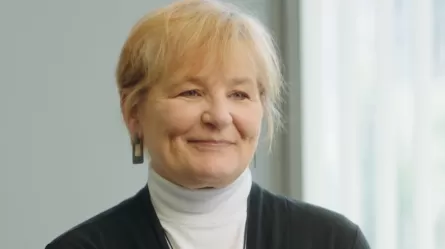 Joanne, a smiling woman with short hair wearing a turtleneck and sweater