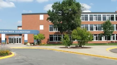 Outside of brick building with name Eisenhower Community Center with trees with leaves in front of it