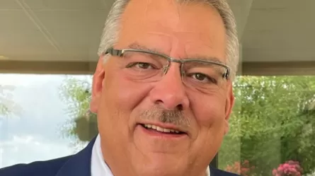 smiling man wearing glasses and a suit and tie