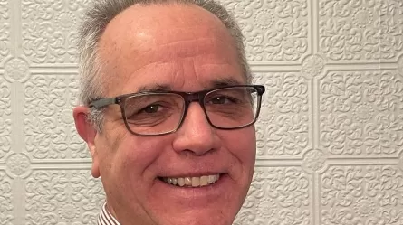 smiling man wearing glasses and button-down shirt