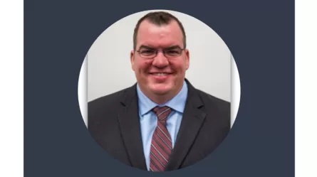smiling man wearing glasses and a suit and tie