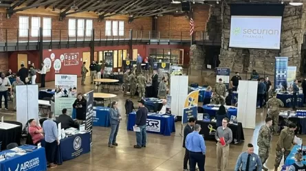 a large room with display tables and people talking to other people at the Second Annual Joint Services Career Fair