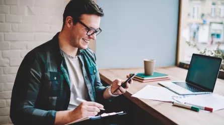 smiling person looking at mobile phone