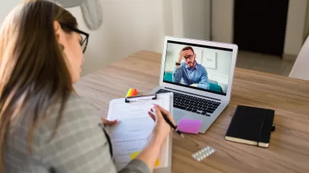 a woman on a laptop participating in a virtual meeting