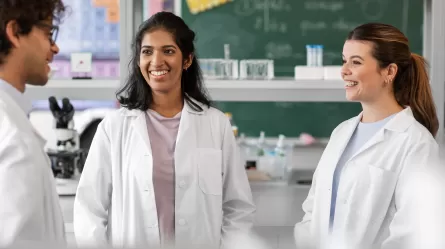 person wearing white lab coat standing in a lab setting