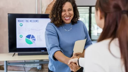 a smiling person shaking hands with another person