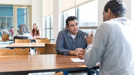 mature job seeker and employer at a desk