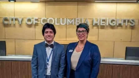 two people wearing suit jackets standing in front of a sign that says City of Columbia Heights
