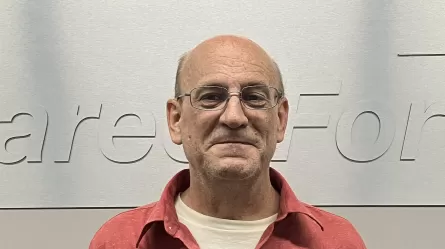 smiling person wearing glasses and a red shirt