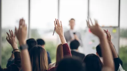 an audience of people with their hands raised