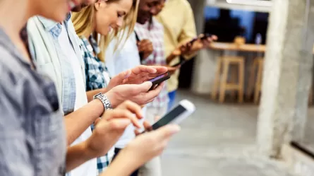 close up of multiple people with their hands on mobile phones