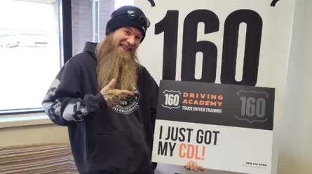 person holding sign that says I just got my CDL