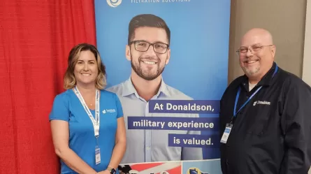 two people standing in front of a banner that says Donaldson Company