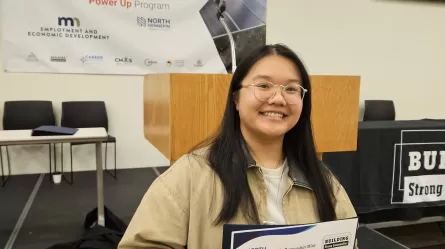 photo of smiling person wearing glasses holding a certificate