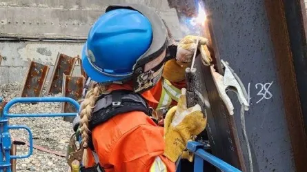 person wearing a helmet and gloves welding a piece of metal