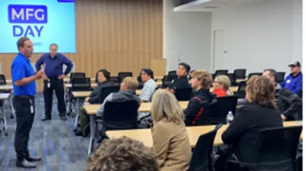 photo of a person presenting to a large room of people