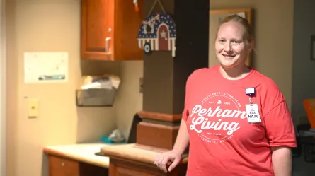 smiling person wearing red perham living shirt 