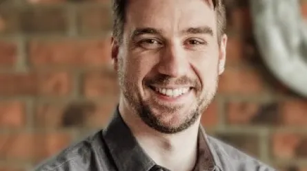 photo of a smiling person wearing a grey shirt