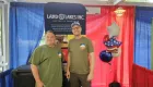 two people standing behind a table with a Land O' Lakes table skirt