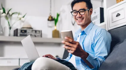 person sitting on a couch looking at a mobile phone