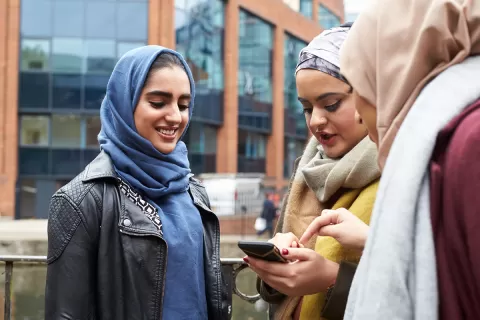 Three women looking at phone