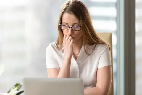 anxious looking woman at a laptop