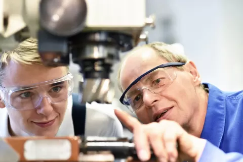 trainee and instructor with manufacturing equipment