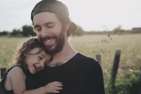 young man holding his child Photo by Caroline Hernandez from Unsplash