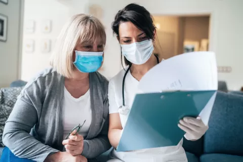 personal care aid and patient both wearing masks