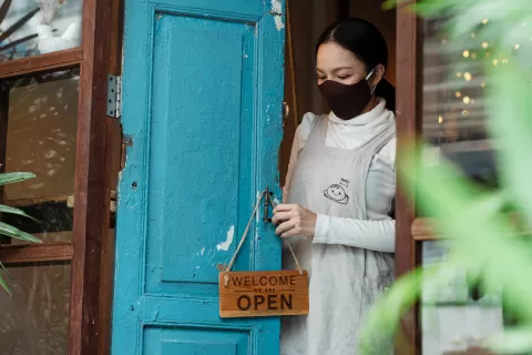 restaurant manager at door of restaurant