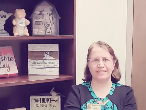 Photo of Rangineh standing by bookshelf.
